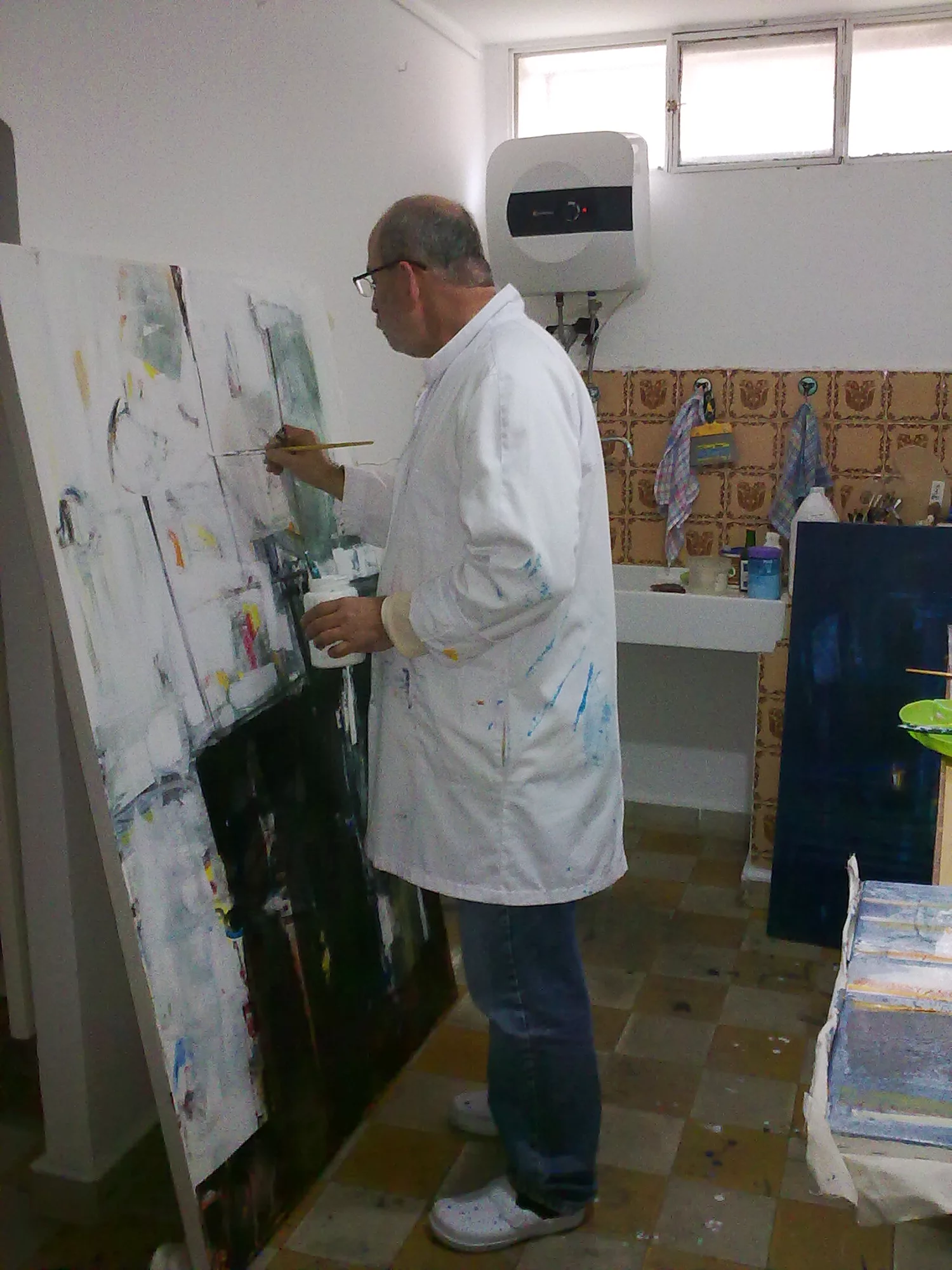 Photo de l'artiste entrain de peindre dans son atelier